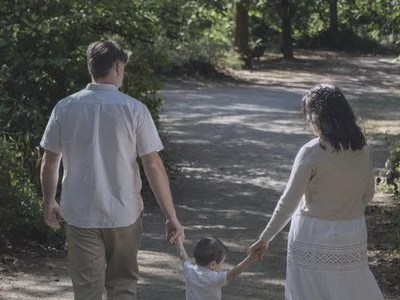 Família caminhando de mãos dadas em um parque